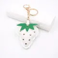 Detail view of a white leather strawberry keychain with gold studs and metal ring - Punk Metal Stud Strawberry / White