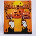 Whimsical Halloween ghost drop earrings with pumpkin detail on festive orange display card - Ghost Hugging Pumpkin