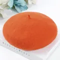 Detailed view of a soft orange wool beret hat showcasing its classic felt texture - One Size / Orange