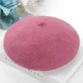Macro detail view of a pink wool beret with soft knitted texture on a white book - One Size / Dusky Pink