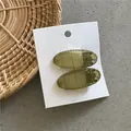 Pair of minimalist translucent olive green oval duckbill hair clips on white display card - Frosted Oval Clip Pair (10-B32) / Translucent Olive Green