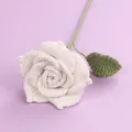Handmade white crochet rose flower with green stem and leaf on purple background - White