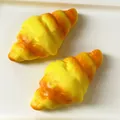 Nahaufnahme der realistischen Textur von zwei langsam aufspringenden Croissant-Spielzeugen - Großes Croissant-Quetschspielzeug