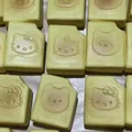 Creamy yellow slow rebound squishy bread toy featuring an embossed cute cartoon cat face - Bitten Cookie [1pc] Random Style