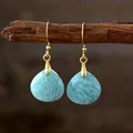 Eleganti orecchini pendenti in pietra naturale a goccia con ganci dorati su un ramo - Amazonite