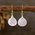 Eleganti orecchini a goccia minimalisti in quarzo rosa con ganci dorati su un ramo - Quarzo rosa