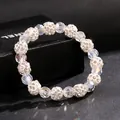 Close-up of sparkling crystal and rhinestone shamballa beads on an elastic bracelet - White