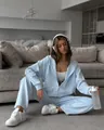 Light blue zip-up hoodie and matching joggers tracksuit set for women in lifestyle setting - S / Blue