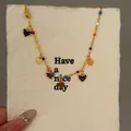 Elegante goldene Fußkette mit bunten Perlen und glitzernden schwarzen Herzanhängern - Schwarzes Herz