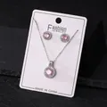 Close-up of elegant pink zircon halo necklace and earrings set on a white display card - Pink