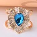 Decorative gold-toned scarf ring with a large blue teardrop gemstone and rhinestones. - Golden Teardrop Blue Stone (DY0006)