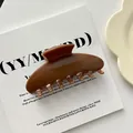 Detailed macro view of a large brown acrylic shell-shaped hair claw clip for elegant styling. - #3 (10cm)