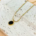 Dettaglio collana dorata con pendente ovale in pietra occhio di gatto nera - Nero (Oro)