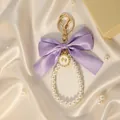 Detailed view of an elegant purple satin bow and pearl bead keychain with gold hardware - Purple Bow (ZJ17027)