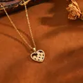 Gros plan d'un pendentif cœur doré avec perles pêche et oxydes de zirconium - Collier Cœur Rond Jaune (238314) / Or