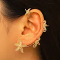 Dettaglio ravvicinato di un ear cuff dorato a tema marino con stelle marine e cavallucci. - Combo Ippocampo e Stella Marina (Orecchio Sinistro) / Oro