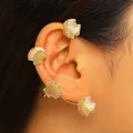Primo piano di un elegante ear cuff a forma di conchiglia dorata indossato su un modello - Stile Conchiglia (Orecchio Destro) / Oro