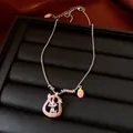 Detail einer süßen Silberkette mit Hasen- und Erdbeeranhängern auf einem Schmucktablett - Halskette / Silber-Rosa-Grün