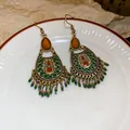 Detailed view of Bohemian ethnic tassel earrings with gold finish, green beads and resin - Gold Green