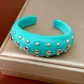 Close-up van turquoise hars manchetarmband met glanzende zilveren ronde noppen - Cuff Bracelet / Cyaan