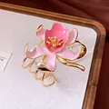 Detailed view of an elegant pink enamel flower open bracelet with gold-toned bands - Pink Flower Style / Gold-Pink