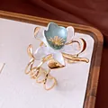 Close-up of vintage gold cuff bracelet with white and teal enamel flower detail. - White Flower Pendant Style / Gold-White-Grey