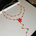Primer plano de conjunto de collar dorado con flores de esmalte rojo y cristales - Collar de doble capa / Dorado-Rojo