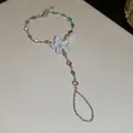Vista detallada de una pulsera de mano plateada con flor de esmalte blanco y cristales de colores - Cadena de mano / Dorado & Blanco & Multicolor