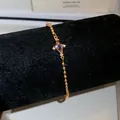 Detailed view of gold beaded bracelet featuring a light blue rhombus zircon stone - Purple Cross Style (HB6074-2) / Gold