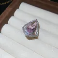 Macro view of a pear-shaped pink gemstone ring with intricate pavé diamond settings. - Open Ring / Pink