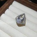 Macro view of teardrop halo ring featuring a large central stone and pave setting. - Open Ring / Silver-White
