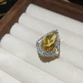 Macro detail of a teardrop yellow gemstone ring with sparkling pavé diamond halo - Open Ring / Yellow