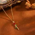 Gros plan d'un collier pendentif tulipe élégant avec pierres rouges et vertes, or - Tulipe (T079) / Collier en zircone rouge / Or