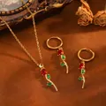 Gros plan d'un ensemble de bijoux rose dorée avec des zircons rouges et verts élégants. - Tulipe (T079) / Parure Collier et Boucles d'Oreilles Strass Rouge / Or
