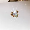 Macro-opname van een fonkelende zirkoonring met rechthoekige en hartvormige stenen - Santa Maria aquamarijn open ring (K259) / Goud