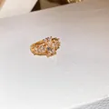 Detailweergave van een vergulde ring met sprankelende ovale en ronde zirkonia's. - Ovale zirkonia duivenei-ring (53#) / Goud