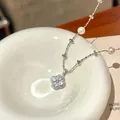 Close-up of a sparkling silver zircon flower pendant on a dainty pearl beaded necklace - Flower Pendant Necklace / Silver