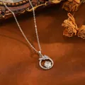 Primo piano di un pendente circolare con design a foglia di zircone scintillante - Collana a Cerchio Foglia / Argento