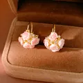 Close-up of pink resin rose flower earrings with sparkling rhinestones in a brown box - Ear Buckle / Gold-Pink