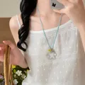 Close-up of a hollow flower pendant necklace with light blue cord for summer outfits - Hollow Flower Style (HN12418-3) / Light Blue