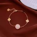 Detailed macro view of 18k gold plated bracelet featuring zircon four-leaf clover charm - Bracelet / Gold-Pink