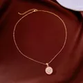 Close-up of a delicate 18k gold plated necklace with a pink clover flower pendant - Necklace / Gold-Pink