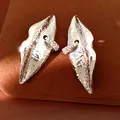 Detailed view of silver metallic lip-shaped earrings with sparkling rhinestone hoop detail. - Silver Earring Post Style / Silver