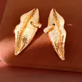 Detailed macro shot of textured gold lip-shaped earrings with sparkling rhinestone rings. - Silver Earring Post Style / Gold