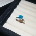 Detail van een zilveren ring met vierkante blauwe edelsteen in een witte sieradendoos - 2# Paraiba Suikerklontje Open Ring / Zilver