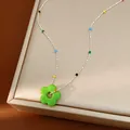 Gros plan d'un collier fleur en verre coloré avec des perles sur une boîte à bijoux - Vert