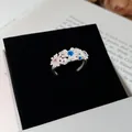 Gedetailleerde opname van een zilverkleurige madeliefjesring met kleurrijke zirkonia's. - Madeliefje Bloem Kleurrijke Zirconia Stijl / Zilver-Kleurrijk