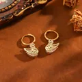 Eleganti orecchini a cerchio a cigno dorati con pietre di zircone su fondo marrone - Orecchini A Cigno T064 In Oro E Diamanti Bianchi