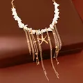 Primo piano di collana con nappe dorate, perline di pietra bianca e ciondolo a stella - Oro (Bianco)
