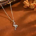 Elegante collana con ciondolo a fenicottero argento e pietre blu su sfondo marrone - Collana T064 Con Fenicottero In Argento E Diamanti Blu